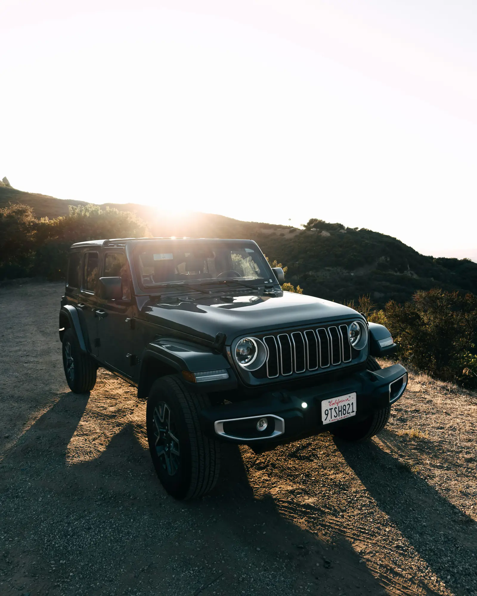 Jeep Wrangler on a mountain track at sunset